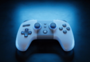 Mando de videojuegos moderno sobre una superficie oscura iluminado con luz azul